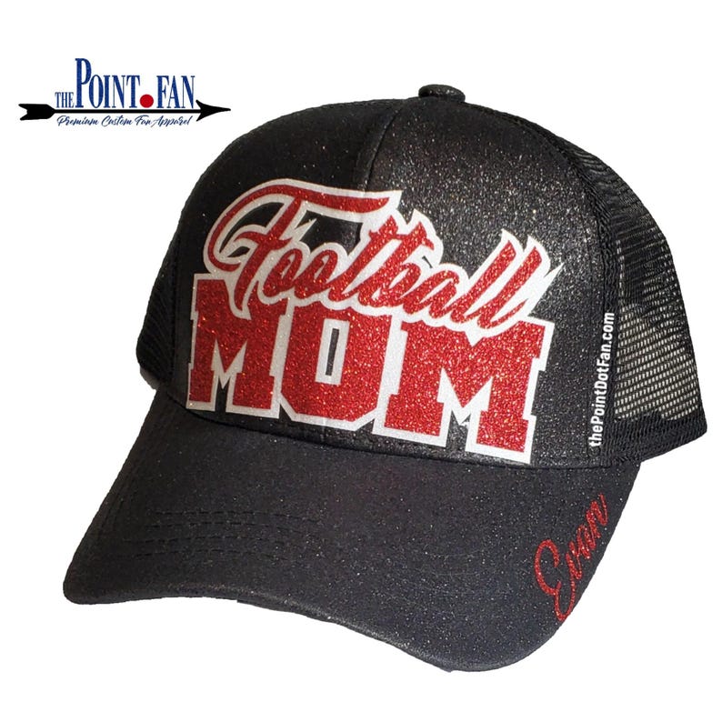 Pode incluir: Um bon&eacute; trucker preto com glitter e o texto Football MOM em glitter vermelho no painel frontal. O nome Evan aparece em glitter vermelho na aba. O texto thePointDotFan.com est&aacute; impresso verticalmente no painel lateral do bon&eacute;.