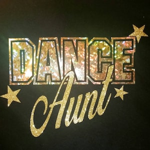 Può includere: Design in glitter dorato da stirare con le parole "Dance Aunt" e due stelle dorate glitter.