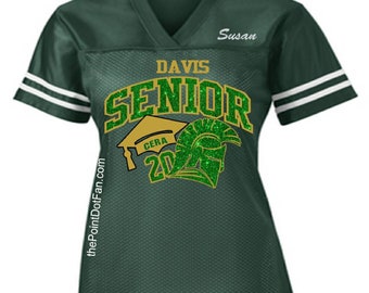May include: Green mesh jersey with white stripes on the sleeves. The jersey features the text "DAVIS SENIOR" in gold and green glitter, along with a graduation cap and a Spartan helmet graphic. The name "Susan" is printed on the upper right.