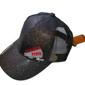 May include: Black glitter trucker hat with a mesh back. The front of the hat features the text "REARADERS MHS Mom" in red and white. The hat has a curved brim and a small button on top. The website "ThePointDotFan.com" is printed on the side.