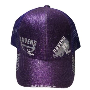 Pu&ograve; includere: Cappellino da camionista viola con paillettes con un designo di paillettes argentate di un pallone da calcio e le parole "Ravens Mom" su un lato e un megafono con le parole "Ravens Mom" sull'altro lato.