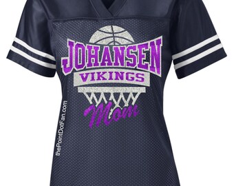 May include: A navy blue basketball jersey with white stripes on the sleeves. The jersey has a purple glitter design with the text "Johansen Vikings" and a basketball hoop with the word "Mom" inside.