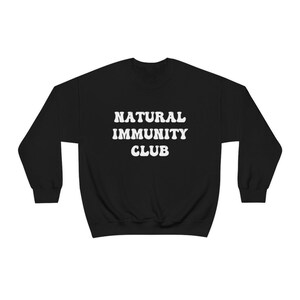 May include: Black sweatshirt with white text that reads "NATURAL IMMUNITY CLUB".