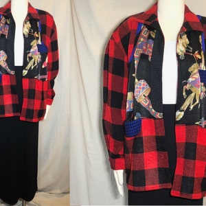 Puede incluir: Una camisa de franela a cuadros rojos y negros con un panel de tela estampado con caballos coloridos en la parte delantera. La camisa tiene una cremallera y dos bolsillos.