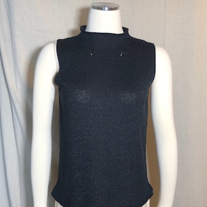 May include: A black sleeveless mock neck sweater.