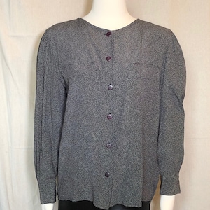 May include: A long-sleeved button-up blouse with a black and white patterned design. The blouse has a round neckline and a relaxed fit.