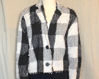 May include: A black and white checkered blazer with a frayed texture. The blazer has a button closure and a collar.