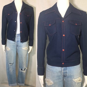 May include: A navy blue jacket with red stitching and buttons. The jacket has a collar and two pockets on the front.