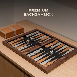 Könnte beinhalten: Ein Backgammon-Set aus Holz mit einem schwarz-weißen Spielfeld und goldfarbenen Spielsteinen. Das Set ist geöffnet und spielbereit, mit Würfeln und Spielsteinen an Ort und Stelle. Das Set ist mit "PREMIUM BACKGAMMON" beschriftet.