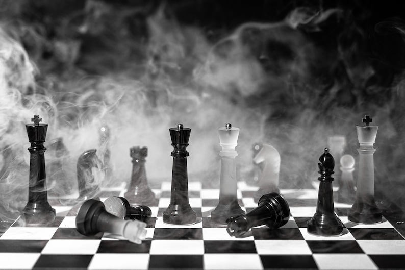 May include: A black and white chessboard with chess pieces arranged in a strategic formation. The board is covered in a thick layer of smoke, creating a dramatic and mysterious atmosphere.