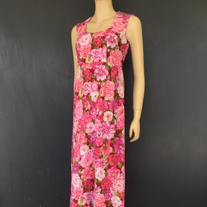 May include: A long, sleeveless maxi dress with a pink and red floral print. The dress has a fitted bodice and a flowing skirt with a ruffled hem.