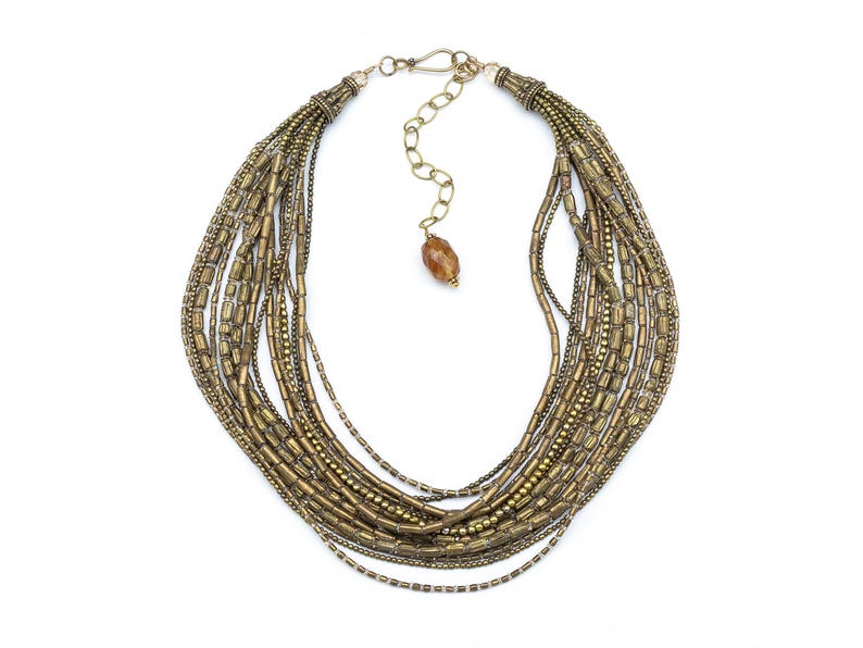 Fifteen strands of vintage African brass tube beads and tiny round Indian brass beads create this luminous, textured multistrand necklace.