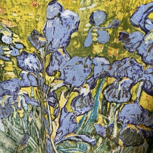 Puede incluir: Un primer plano de un tapiz con un dise&ntilde;o floral vibrante. El tapiz representa un grupo de iris p&uacute;rpuras con hojas verdes sobre un fondo amarillo. La tela tiene una apariencia texturizada y tejida.