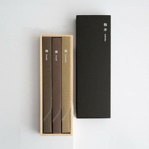 May include: Three wooden boxes containing incense sticks. The boxes are labeled "Hinoki", "Kyoki", and "Kunouki". The boxes are arranged in a row on a white surface. The text "和木 waboku" is printed on a black box.