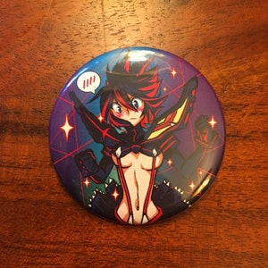 May include: A round button with a colorful anime character wearing a black and red outfit with a red and white speech bubble that says "!!!". The background is a dark blue with red and white stars.