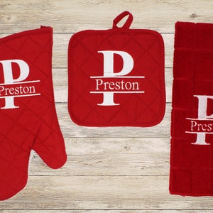 May include: Red kitchen towel, pot holder, and oven mitt set with white embroidered lettering that says "Preston" with a large "P" above the name.