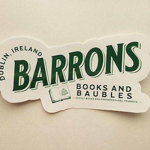 May include: A white sticker with green text that reads "Barrons Books and Baubles - Occult Books and Preternatural Trinkets - Dublin, Ireland". The sticker features a green illustration of a book with a Celtic knot.
