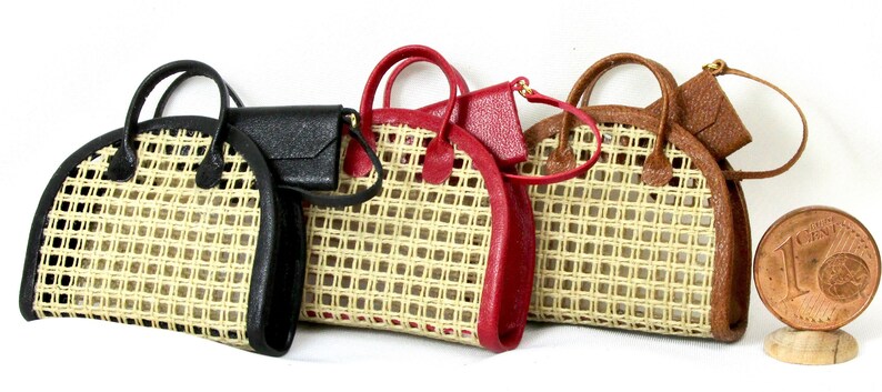 K&ouml;nnte beinhalten: Drei geflochtene Strohtaschen mit Lederbesatz. Die Handtaschen sind in Schwarz, Rot und Braun.