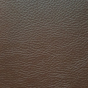 May include: Close-up of a brown leather texture with a pebbled surface.