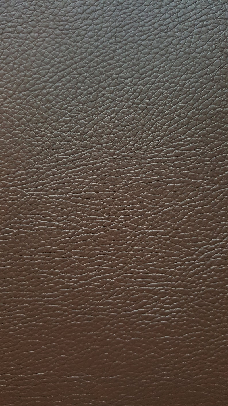 May include: Close-up of a brown leather texture with a pebbled surface.