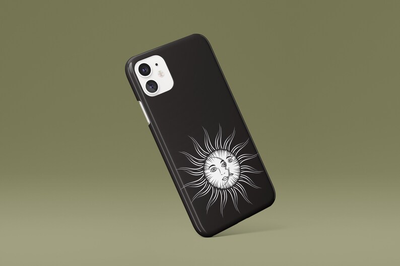 May include: Black phone case with a white sun and face design.