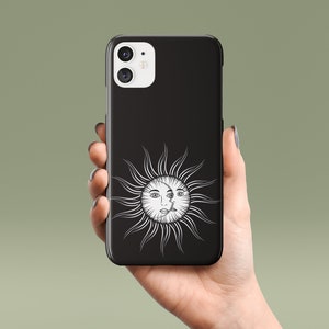 May include: Black phone case with a white sun and moon design. The sun has a face and the moon has a crescent shape.