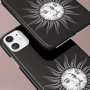 May include: Two black phone cases with a white sun and moon design. The sun and moon have faces and are surrounded by rays.
