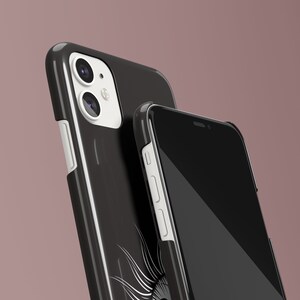 May include: Two black phone cases with white accents. The case on the left has a camera lens cutout and a white border. The case on the right has a black screen and a white border.