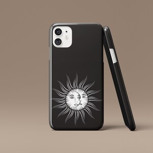 May include: Black phone case with a white sun and moon design. The sun has a face and the moon is a crescent shape.