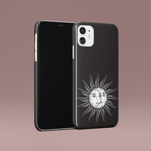 May include: Black phone case with a white sun and face design. The phone case is for an iPhone.