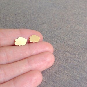 May include: A pair of gold cloud-shaped stud earrings.