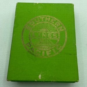 Puede incluir: Caja verde con un círculo en relieve dorado que dice "Southern Railway Lines" en un diseño circular.