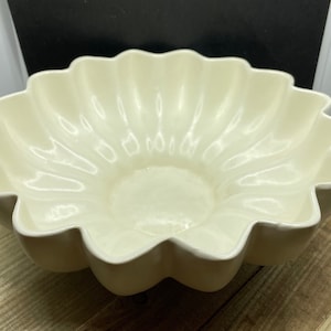 May include: A white ceramic bowl with a scalloped edge and a fluted design. The bowl is empty and has a glossy finish.