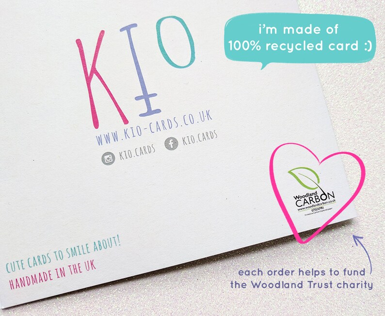 May include: White card with the KIO logo in pink and teal. Text includes "i'm made of 100% recycled card :)" and "Cute cards to smile about! Handmade in the UK." A heart-shaped logo with "Woodland CARBON" is also visible.