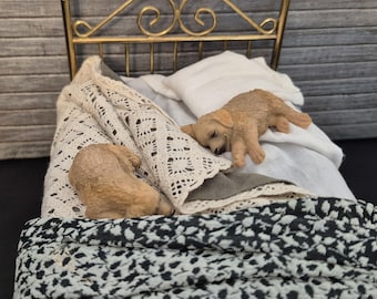 Miniatuur onopgemaakt koperen bed met 2 slapende honden