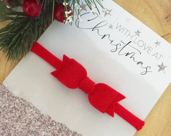 May include: Red felt bow headband with a white card that says "With Love at Christmas" with silver glitter stars.