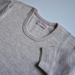 May include: A light grey long-sleeved shirt with a white tag that reads "Enell's" and "manmade fibres" in red lettering.