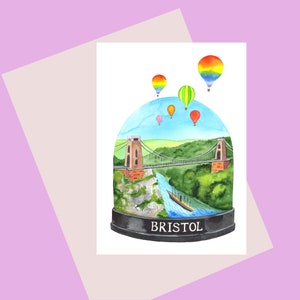 Bristol in una carta Snow Globe-A6 che mostra l'iconica scena del ponte sospeso di Clifton, palloncini e la nave SS Great Britain di Brunel Bristol