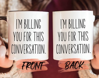 May include: White ceramic mug with a black rim and handle. The mug has the text "I'm billing you for this conversation." on the front and back.