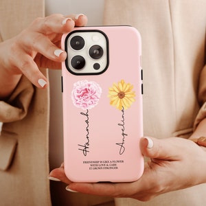 May include: A pink phone case with a pink carnation and a yellow sunflower design. The names "Hannah" and "Angelina" are written vertically. The quote "Friendship is like a flower with love & care it grows stronger" is also included.