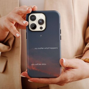 May include: A blue phone case with a sunset background and the text "no matter what happens you will be okay."
