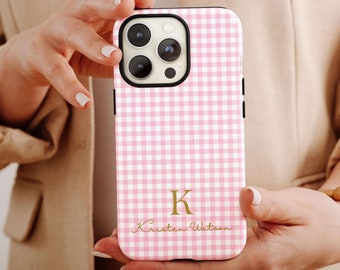 May include: Pink and white gingham phone case with a gold initial "K" and the name "Kristen Watson" printed on the back.