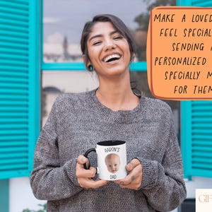 A woman is holding a personalized mug with a picture of a baby, smiling and posing for the camera.