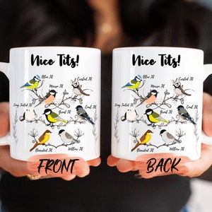 May include: White ceramic mug with a black outline of a tree branch with various birds on it. The text "Nice Tits!" is printed on the mug. The front of the mug shows the birds with their names, such as "Blue Tit", "Crested Tit", "Long Tailed Tit", "Great Tit", "Coal Tit", "Bearded Tit", and "Willow Tit". The back of the mug shows the same birds with their names.