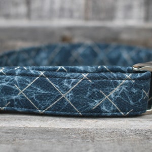 Peut inclure: Un collier de chien bleu avec un motif g&eacute;om&eacute;trique blanc et une boucle argent&eacute;e.