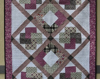 Handmade throw quilt in lilac and black fabrics, with a black backing, custom quilted in a very detailed machine quilted pattern