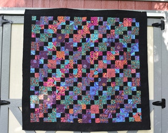 Handmade, machine quilted throw quilt or wall handing with a black back & colorful front.  Pattern available for a custom made memory quilt.