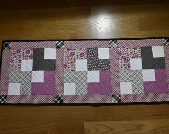 Handmade lilac, gray and black table runner with black backing and custom machine quilted.