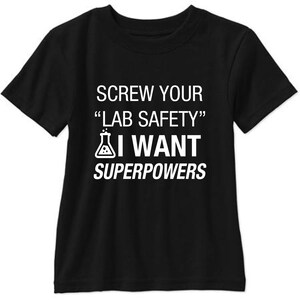 May include: Black t-shirt with white text that reads "Screw your "Lab Safety" I want superpowers". A beaker icon is next to the text.