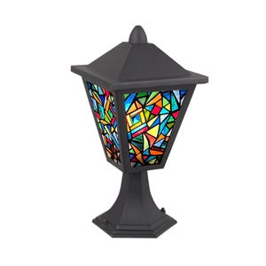 May include: A black outdoor lamp with a stained glass design. The lamp features a geometric shape with a multi-coloured stained glass panel. It is supported by a pedestal base and has a pointed top.